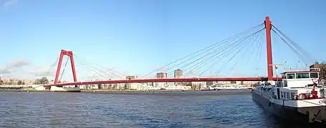 pont rouge sur une rivière avec une péniche