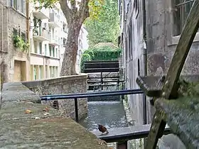 Gros plan sur une roue et canal bordant la rue des Teinturiers