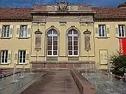 La façade de l'ancien tribunal : fenêtres à balustrades, parements, fronton à blason.