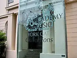 a classical building with a modern sign identifying it as the Royal Academy of Music