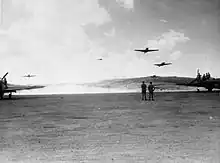 Photo noir et blanc d'avions décollant d'une piste en terre