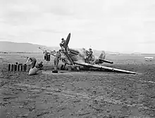 Mécaniciens travaillant sur un avion dans un paysage désertique