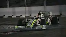 Vue à travers des grillages de la BGP 001 de Barrichello dans la nuit de Singapour