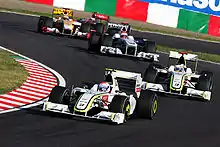 Les BGP 001 de Barrichello et Button menant le peloton dans une série de virages à Suzuka