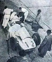 Photo en plongée de Rudolf Caracciola dans sa voiture pendant un ravitaillement.