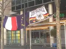 Les drapeaux français, européen et allemand accrochés entre deux arbres face au restaurant La 3e Mi-Temps.