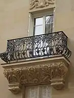 Les balcons en fer forgé avec soubassement sculpté.