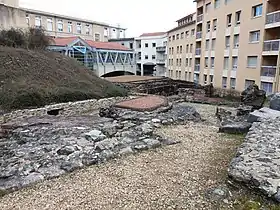 Vestiges des thermes romains de la rue des Farges. Au second plan, la façade méridionale du collège Jean-Moulin.