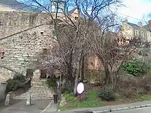Vue d'une muraille à partir d'une rue en contrebas et de maisons anciennes