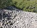 ruines d'un bâtiment majeur (tas de pierres sèches, d'environ 20m de longueur sur 2m de hauteur) au centre-est de l'oppidum.