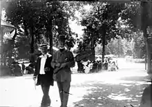 Photographie de deux hommes marchant dans la rue.