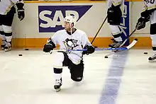 Photo de Ryan Whitney un genou sur la glace.