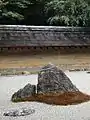 Le mur d'argile, qui est souillé par l'âge avec des tons brun et orange subtils, reflète wabi, le jardin de pierres sabi.