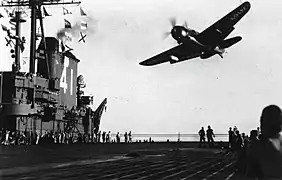 SB2C-4E de la VT-74 au-dessus de l'USS Midway (CV-41). Le pod radar APS-4 est visible sous l'aile (1946).