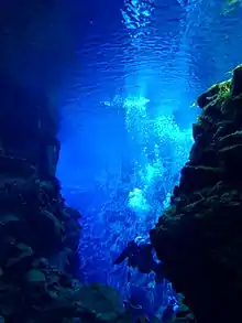 Plongeur dans des eaux bleues au cœur d'une faille.