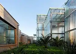 Photographie de la verdure du Jardin Botanique entouré de bâtiments en verre modernes.