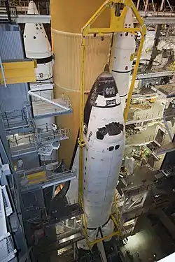 La navette spatiale américaine Atlantis  est fixée au réservoir central et aux propulseurs d'appoint à poudre dans l'une des quatre baies d'assemblage du VAB.