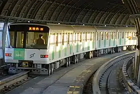 Photographie montrant une rame de métro en fonctionnement de couleurs verte et blanche.
