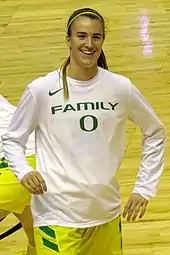 Une joueuse de basket-ball en survêtement d'entraînement, souriante.