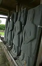 Gisants de pierre médiévaux exposés sur des chevalets.