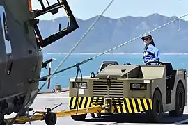 Remorqueur d'aviation EINSA sur le pont tractant un hélicoptère.