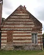 Vieille maison en brique et en pierre calcaire avec une pierre gravée portant la mention M 1805 P.