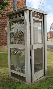 Ancienne cabine téléphonique recyclée en boîte à livres.