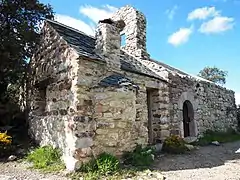 Face sud et angle sud-ouest. À gauche du clocher, avec une toiture en ardoise et un four à pain, le refuge ajouté lors de la restauration en 1990.