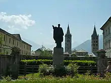 Statue de Saint Anselme d'Aoste, rue Xavier de Maistre. À l'arrière-plan, les clochers de la cathédrale d'Aoste, à droite on entrevoit le grand séminaire