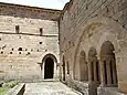 Cloître avec entrée de l'église et à droite entrée de la salle capitulaire.