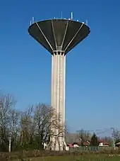 Une haute tour surmontée d'un réservoir en forme de cône inversé.
