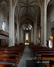 Photographie couleur de la nef et des voûtes d'une grande église gothique.