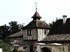 Maison à colombages surmontée d'un pigeonnier décoratif.