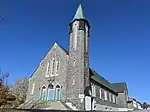 Une église en pierre, avec un clocher excentré.