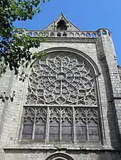 Photographie d'un pignon de transept d'église, avec une rose à remplage rayonnant