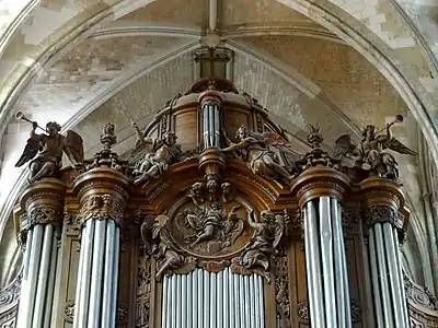 Parties supérieures d'un grand buffet d'orgue en bois, surmontées d'une croix et de quatre statues d'anges dont deux soufflant dans des trompettes.