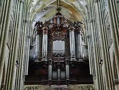 Grand buffet d'orgue en bois, surmonté d'une croix et de quatre statues d'anges dont deux soufflant dans des trompettes.