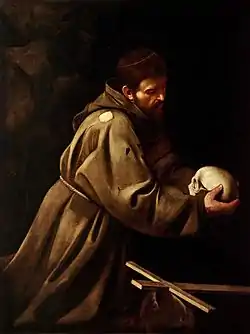 Peinture d'un homme en robe de bure, agenouillé, qui contemple un crâne humain.