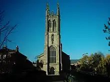 photo en couleur d'une église avec un haut clocher-porche quadrangulaire