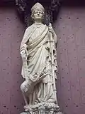 Photo de la statue de Saint-Romain sur le trumeau du portail des Libraires avec une gargouille à ses pieds