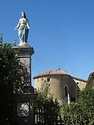 Statue de la Vierge Marie avec l'église en arrière-plan.