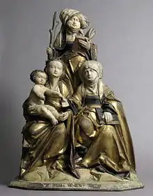 Groupe statuaire en bois représentant 3 femmes et un bébé.