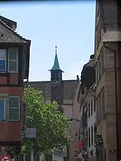 Un clocher d'église, avec des maisons sur les côtés.