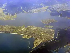Vue aérienne couleur d'un port maritime, s'étendant entre deux étendues d'eau.