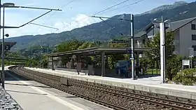 Double-tracked railway line with canopy-covered concrete platforms