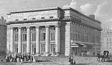Lithographie noir et blanche d'un bâtiment à colonnades lieu de théâtre avant première destruction par un incendie.