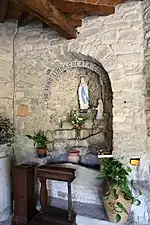 Niche abritant une statue de Marie dans une église romane.