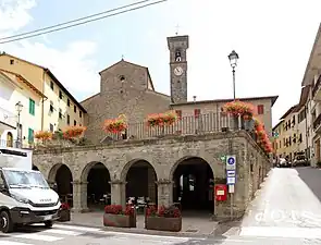 La façade d'une église romane située au milieu d'un village toscan.