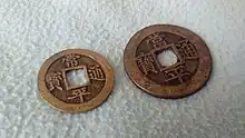 Photographie de deux pièces de monnaie en métal, de deux tailles différentes.
