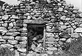 Entrée ménagée dans le pignon-façade, sous la pointe du fronton. Une porte en bois s'articulait sur des gonds fichés dans le chambranle en bois.